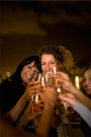simsearch:6122-08229507,k - People toasting at party at night Fotografie stock - Premium Royalty-Free, Codice: 649-03857293