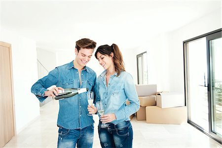 pouring champagne - Couple drinking champagne in new home Stock Photo - Premium Royalty-Free, Code: 649-03857361