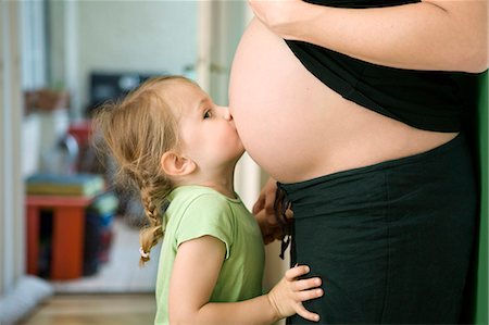 pregnant mother and child - Girl kissing pregnant mother's belly Stock Photo - Premium Royalty-Free, Code: 649-03857501