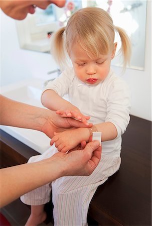 simsearch:649-08661261,k - Mother putting bandage on toddler girl Foto de stock - Royalty Free Premium, Número: 649-03857873