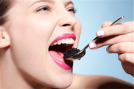 Smiling woman eating caviar Stock Photo - Premium Royalty-Free, Code: 649-03857976