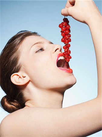 Woman eating bunch of cranberries Stock Photo - Premium Royalty-Free, Code: 649-03857992