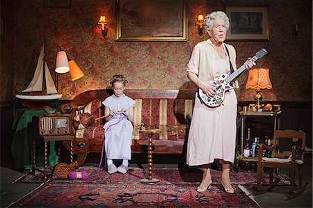 sitting knitting - Older woman playing guitar as girl knits Stock Photo - Premium Royalty-Free, Code: 649-03858052