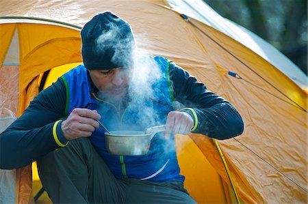 steaming pot - Man cooking food by camping tent Stock Photo - Premium Royalty-Free, Code: 649-03858404