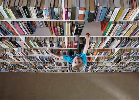 simsearch:649-06812233,k - Boy climbing bookshelves Foto de stock - Sin royalties Premium, Código: 649-03858840