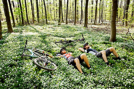 Mountain bikers relaxing in forest Foto de stock - Sin royalties Premium, Código de la imagen: 649-03884367