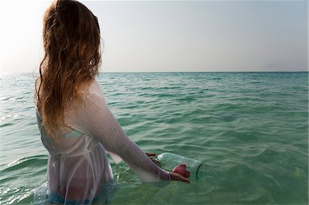 Woman in sea with message in a bottle Stock Photo - Premium Royalty-Free, Code: 649-03881298