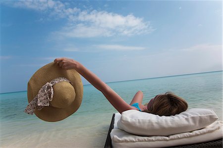 relaxing in lounge chair - Woman relaxing on daybed at beach Stock Photo - Premium Royalty-Free, Code: 649-03881349