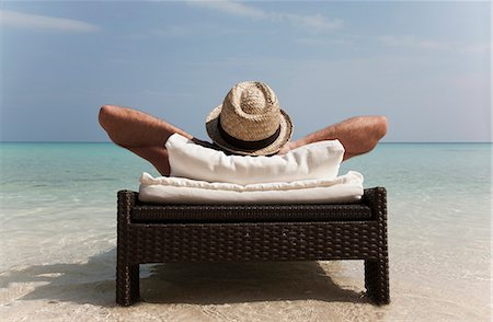 simsearch:628-00919233,k - Man relaxing on daybed at tropical beach Stock Photo - Premium Royalty-Free, Code: 649-03881351