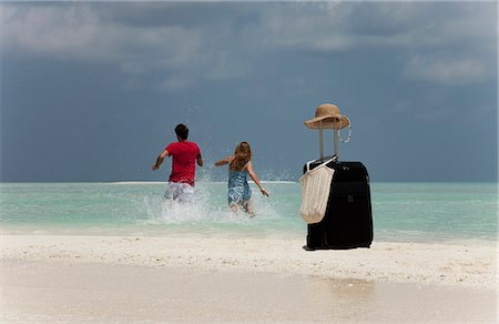 running hat - Couple abandoning luggage on beach Stock Photo - Premium Royalty-Free, Code: 649-03881480