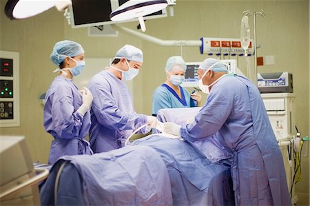 sala operatoria - Doctor and nurses performing operation Fotografie stock - Premium Royalty-Free, Codice: 649-03881679