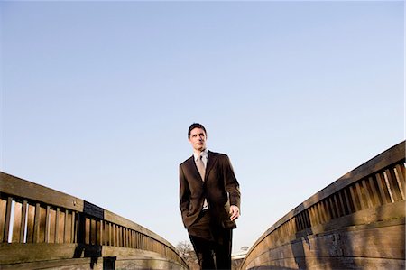 Businessman standing on wooden walkway Stock Photo - Premium Royalty-Free, Code: 649-03881838