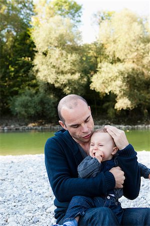 Father holding crying baby by creek Stock Photo - Premium Royalty-Free, Code: 649-03881873