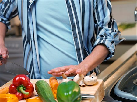 simsearch:6113-06626533,k - Man chopping vegetables in kitchen Stock Photo - Premium Royalty-Free, Code: 649-03881928