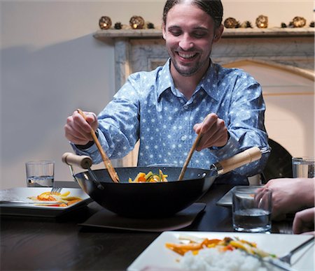 dinner in water - Man serving dinner from wok Stock Photo - Premium Royalty-Free, Code: 649-03881932