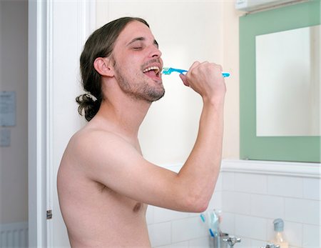 Man brushing his teeth in bathroom Foto de stock - Sin royalties Premium, Código: 649-03881940