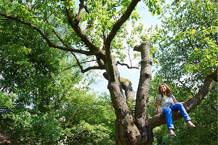 subir - Smiling girl climbing tree outdoors Foto de stock - Sin royalties Premium, Código: 649-03882212