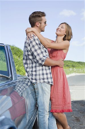 simsearch:649-03465638,k - Couple hugging by convertible Fotografie stock - Premium Royalty-Free, Codice: 649-03882317