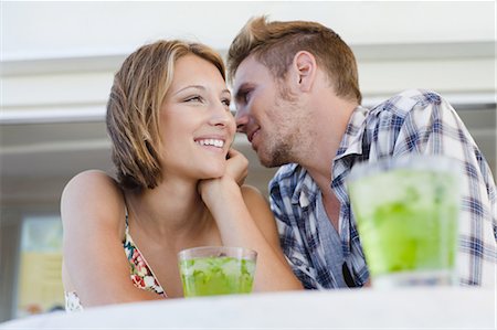 romantic couple cafe - Couple whispering together at cafe Stock Photo - Premium Royalty-Free, Code: 649-03882352