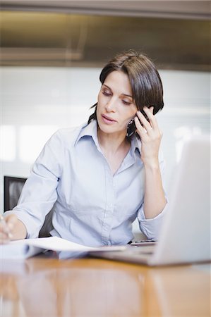 Businesswoman on cell phone and laptop Stock Photo - Premium Royalty-Free, Code: 649-03882419