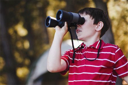 Boy using binoculars at campsite Stock Photo - Premium Royalty-Free, Code: 649-03882543