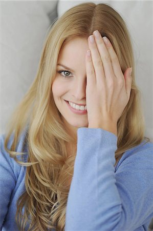 shy (people) - Smiling woman covering one eye Stock Photo - Premium Royalty-Free, Code: 649-03883190