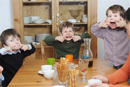 sacando la lengua - Boys making faces at table Foto de stock - Sin royalties Premium, Código: 649-03883239