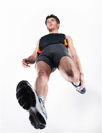 portrait of a runner - Low angle view of man stretching Stock Photo - Premium Royalty-Free, Code: 649-03883367