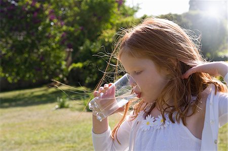 Girl drinking glass of water in backyard Foto de stock - Sin royalties Premium, Código: 649-03883469