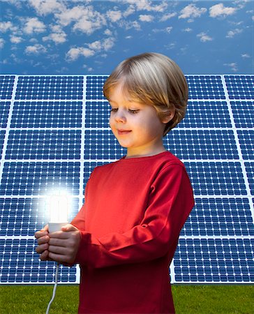 Boy with light bulb by solar panel Stock Photo - Premium Royalty-Free, Code: 649-03883525