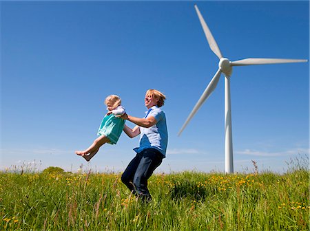 Man in daughter in field by wind turbine Foto de stock - Sin royalties Premium, Código: 649-03883527