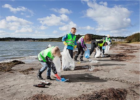 people picking up trash on the beach