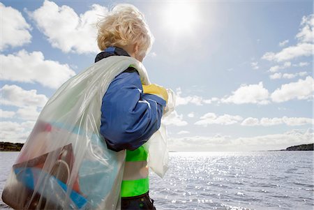 people clean nature - Boy hauling bag of trash on beach Stock Photo - Premium Royalty-Free, Code: 649-03883635