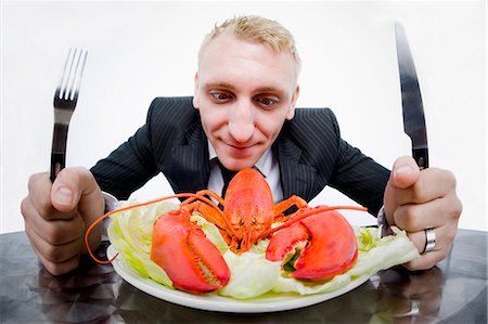 eating seafood restaurant - Businessman eating plate of lobster Stock Photo - Premium Royalty-Free, Code: 649-03883642