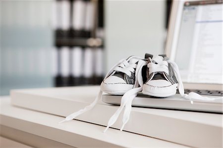 shoes still life - Baby shoes on laptop Stock Photo - Premium Royalty-Free, Code: 649-03883923