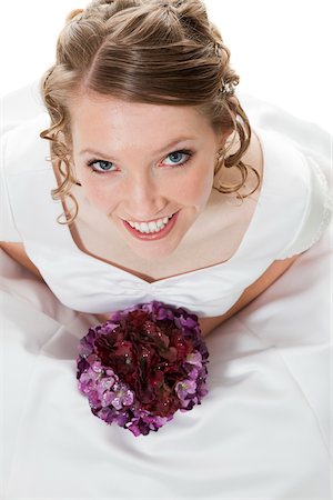 Portrait of happy bride holding bouquet, studio shot Stock Photo - Premium Royalty-Free, Code: 640-05760847