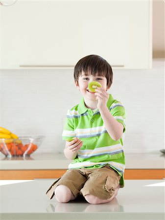 USA, Utah, Portrait of smiling boy (4-5) holding slice of kiwi Foto de stock - Sin royalties Premium, Código: 640-05761000