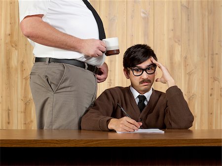 simsearch:640-05761202,k - Boss by uncomfortable businessman at desk in office Foto de stock - Royalty Free Premium, Número: 640-05761198