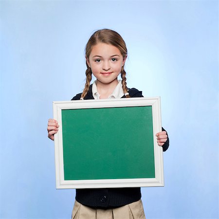showing - Studio portrait of girl (10-11) holding blank green chalkboard Stock Photo - Premium Royalty-Free, Code: 640-05761274