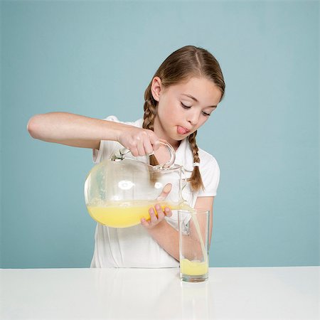 Studio shot of girl (10-11) pouring lemonade Stock Photo - Premium Royalty-Free, Code: 640-05761278
