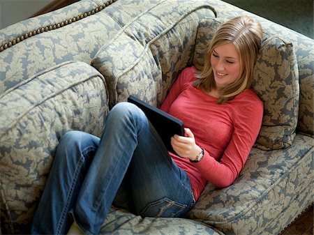 simsearch:640-05761336,k - USA, Utah, Cedar Hills, Teenage girl (14-15) lying on sofa, using digital tablet Foto de stock - Sin royalties Premium, Código: 640-05761339