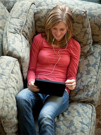 earbuds - USA, Utah, Cedar Hills, Teenage girl (14-15) se trouvant sur l'écoute de la musique d'à l'aide de la tablette numérique Photographie de stock - Premium Libres de Droits, Code: 640-05761340