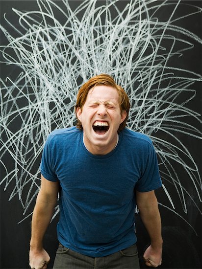 Studio shot of man yelling with chalk scribble on blackboard Stock Photo - Premium Royalty-Free, Image code: 640-05761441