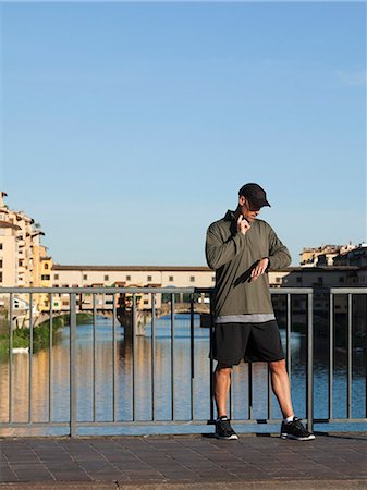 entrenador deportivo (hombre) - Italy, Florence, Man checking pulse on bridge over River Arno Foto de stock - Sin royalties Premium, Código: 640-06049832