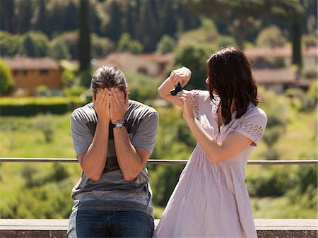 ethnic couple enjoying house - Italy, Florence, Young woman photographing young man in rural area Stock Photo - Premium Royalty-Free, Code: 640-06049937