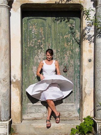 Italy, Ravello, Woman standing in front of watered wooden door, wind blowing woman's dress Foto de stock - Sin royalties Premium, Código: 640-06050065