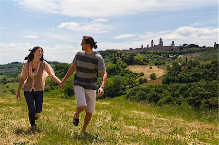 simsearch:640-06050244,k - Italy, Tuscany, San Gimignano, Young couple running on meadow Stock Photo - Premium Royalty-Free, Code: 640-06050330