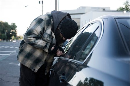 USA, Utah, Salt Lake City, Homeless man breaking into car, side view Fotografie stock - Premium Royalty-Free, Codice: 640-06050719