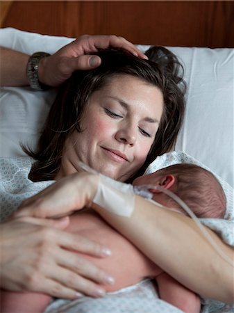 father at bed being hug - USA, Utah, Payson, Mother embracing newborn baby Stock Photo - Premium Royalty-Free, Code: 640-06050792