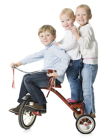 side profile jeans for girls - three children on a tricycle Foto de stock - Sin royalties Premium, Código: 640-06050839